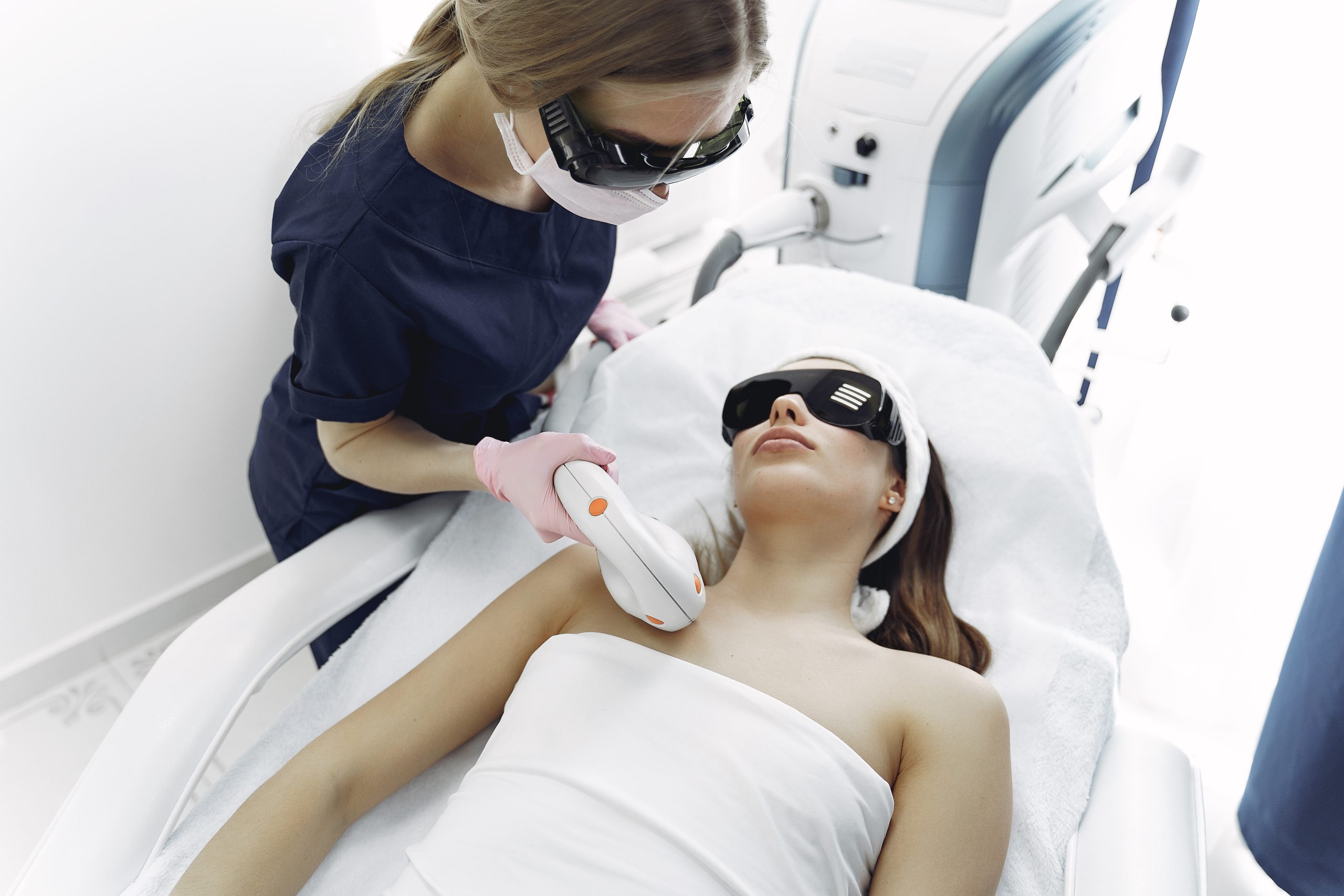 Cosmetologist use laser. Woman with cosmetologist. Lady in a beauty studio.